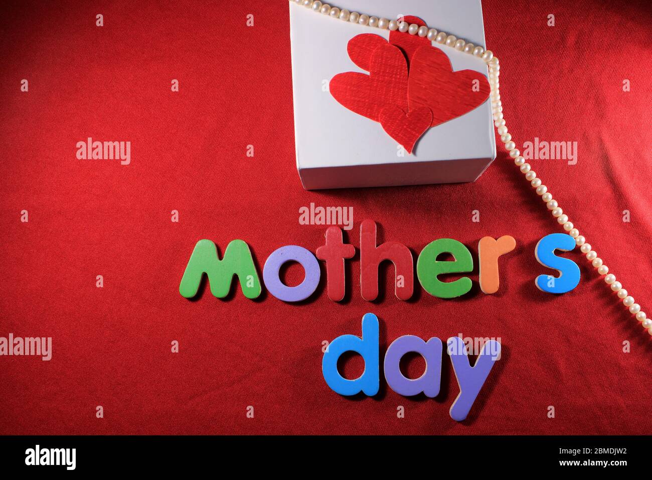 Muttertag geschrieben von bunten Alphabet Blöcke auf rotem Hintergrund angeordnet. Muttertag Geschenkbox. Mutter`s Tageskonzept. Botschaft zum Muttertag. Stockfoto